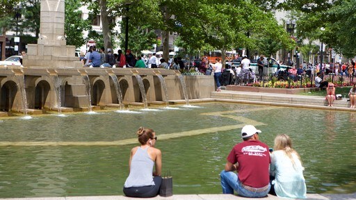 Back Bay featuring a pond and a fountain as well as a small group of people