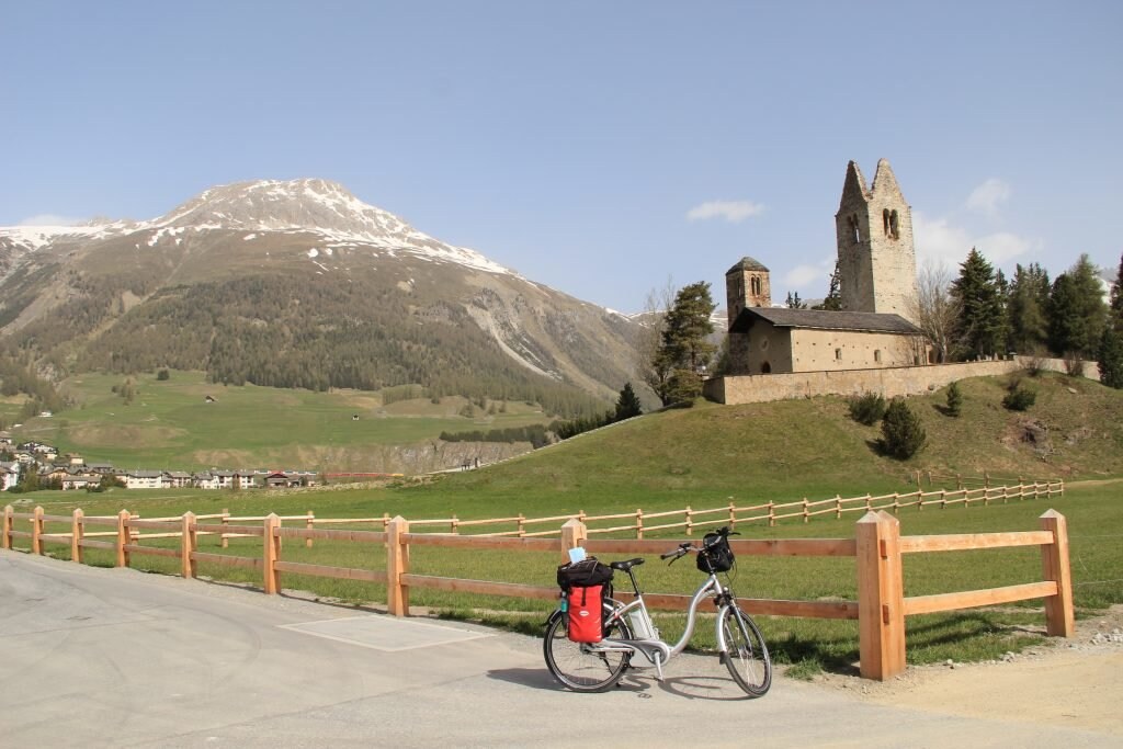 Schweizer Landschaft mit Kirche, Alpen und Fahrrad