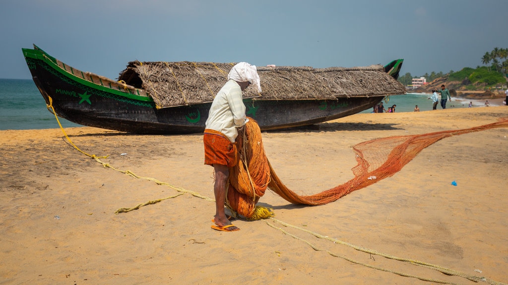 Playa Kovalam mostrando una playa de arena y también un hombre