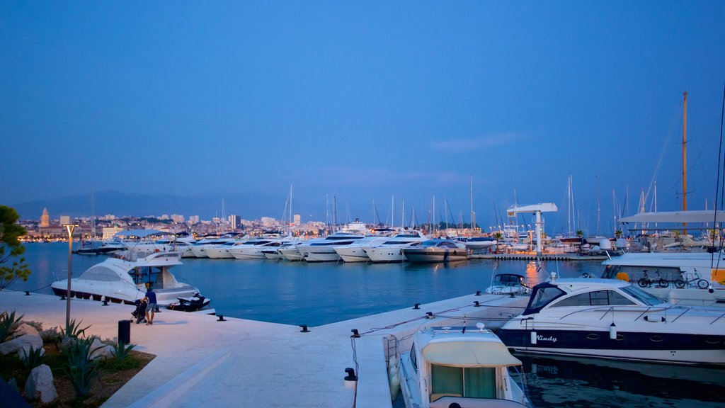 Puerto deportivo ofreciendo escenas de noche, botes y una bahía o un puerto