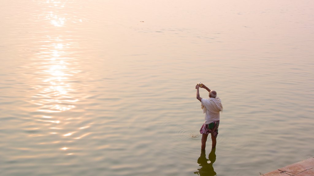 Tulsi Ghat mostrando um lago ou charco, um pôr do sol e pesca