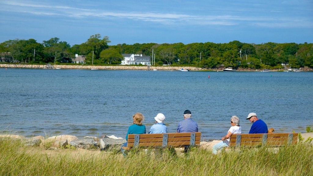 West Dennis Beach que incluye una bahía o un puerto y vista general a la costa y también un pequeño grupo de personas