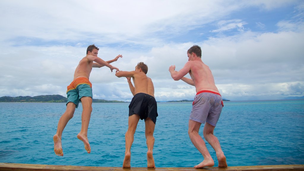 Fiji ofreciendo vistas de una costa y natación y también un grupo pequeño de personas