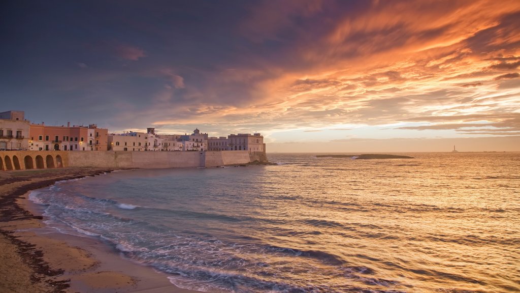 Gallipoli caracterizando um pôr do sol, uma cidade litorânea e uma praia de areia