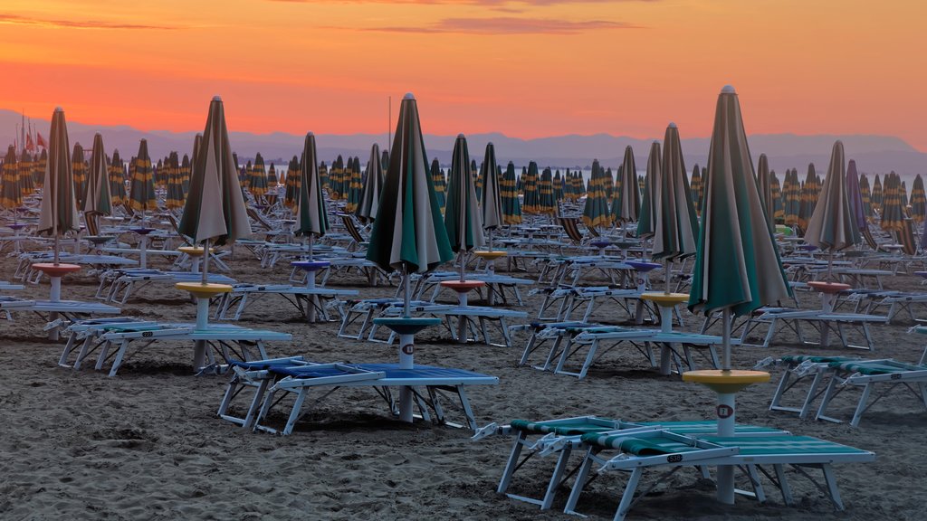 Lignano Sabbiadoro which includes a sunset and a sandy beach