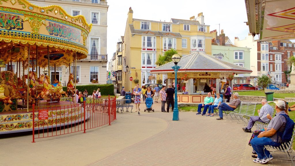 Plage de Weymouth mettant en vedette manèges aussi bien que un petit groupe de personnes