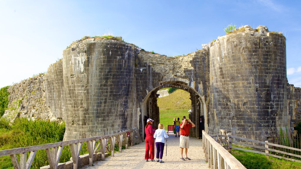 Corfe Castle que incluye elementos patrimoniales y ruinas de un edificio y también un pequeño grupo de personas