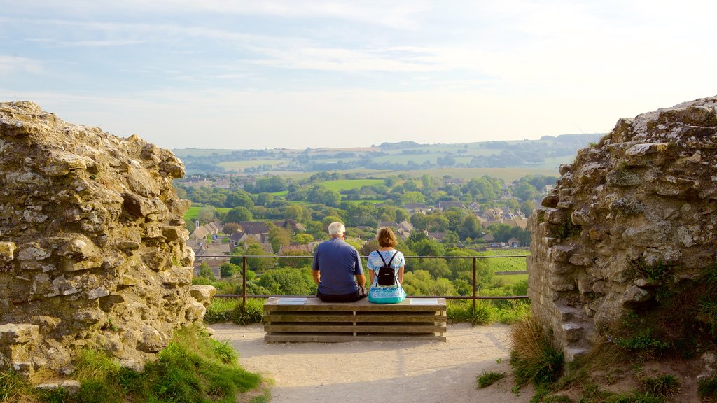 Corfe Castle som omfatter bygningsruiner, en lille by eller en landsby og fredfyldte omgivelser