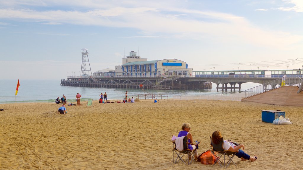 Bournemouth Beach which includes a sandy beach as well as a small group of people