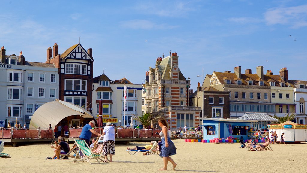 Weymouth Beach showing a sandy beach and a house as well as a small group of people