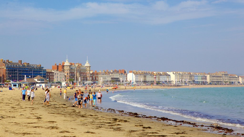 Weymouth Beach featuring a beach as well as a small group of people