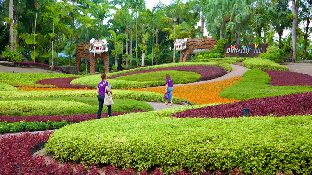 Jardim Botânico Tropical de Nong Nooch que inclui um parque assim como um pequeno grupo de pessoas