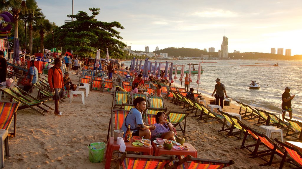 Pattaya Beach showing a beach and a sunset as well as a large group of people