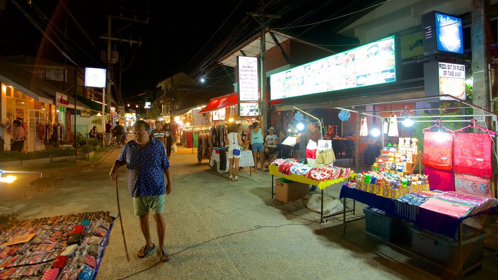 Fisherman\'s Village featuring night scenes and markets as well as an individual male