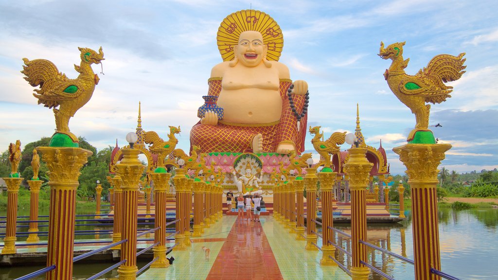 Wat Plai Laem which includes a temple or place of worship, a statue or sculpture and religious aspects