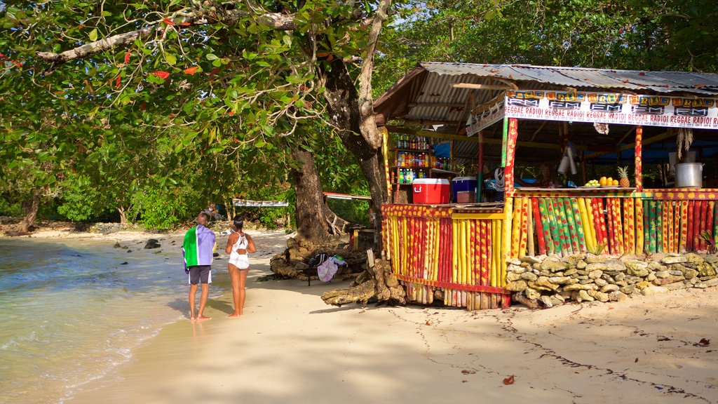 Playa Winnifred que incluye un bar de playa y una playa de arena y también un pequeño grupo de personas