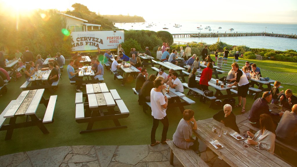 Portsea which includes a sunset and outdoor eating as well as a large group of people