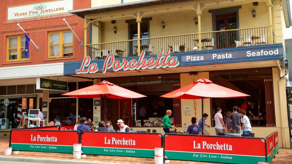 Mornington featuring signage and outdoor eating as well as a small group of people