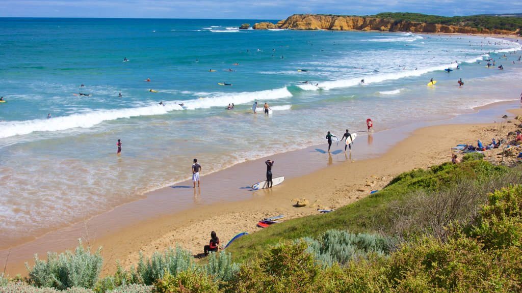 Torquay which includes a sandy beach as well as a large group of people