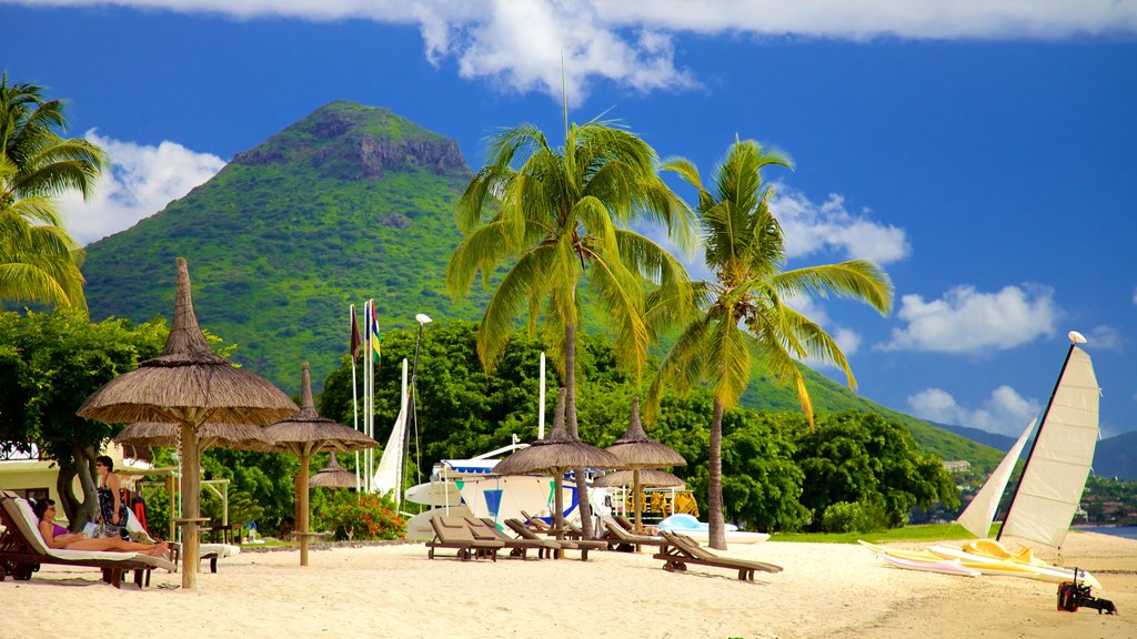 Flic-en-Flac showing a sandy beach, a luxury hotel or resort and mountains