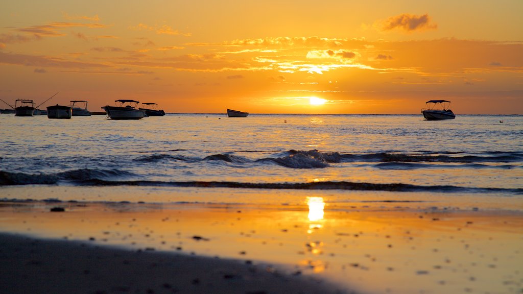 Tamarin que incluye un atardecer, una playa y botes