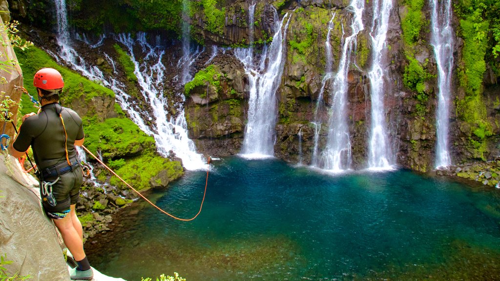 Reunión ofreciendo un lago o espejo de agua y cataratas y también un hombre