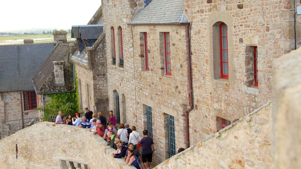 Le Mont-Saint-Michel which includes a small town or village and heritage elements as well as a large group of people