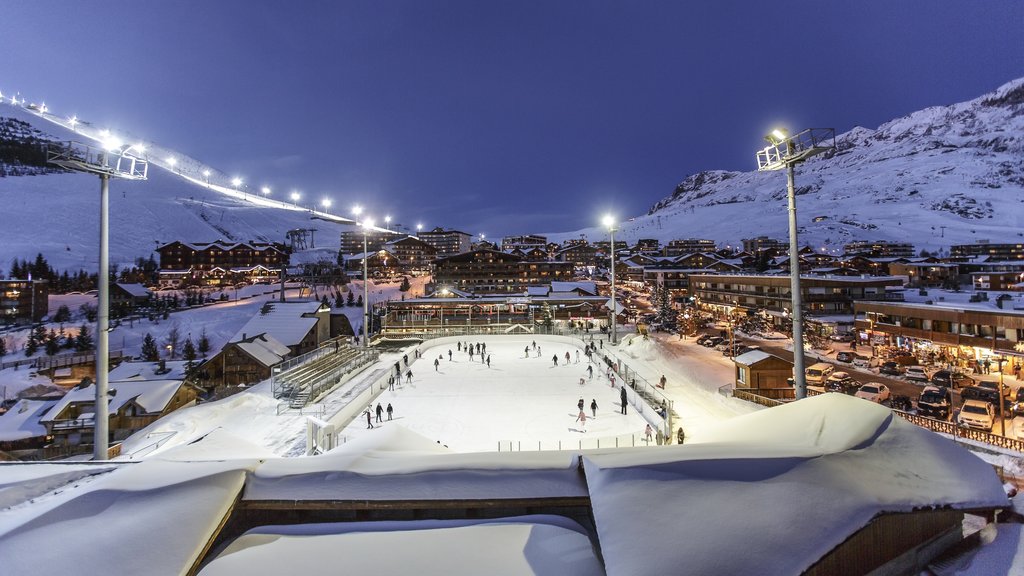 Huez ofreciendo nieve, una pequeña ciudad o pueblo y patinaje sobre hielo