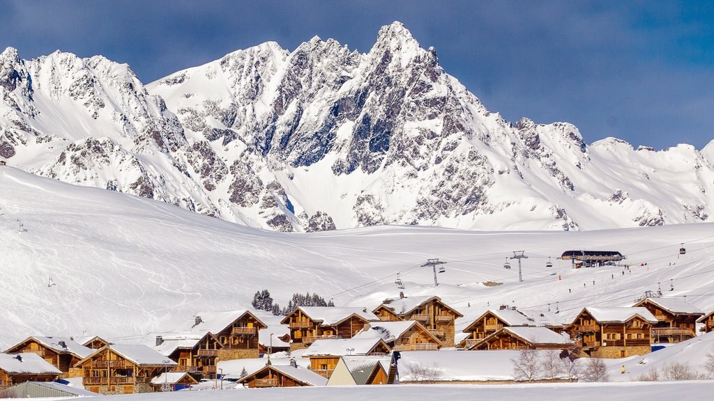 Huez featuring mountains, snow and a small town or village