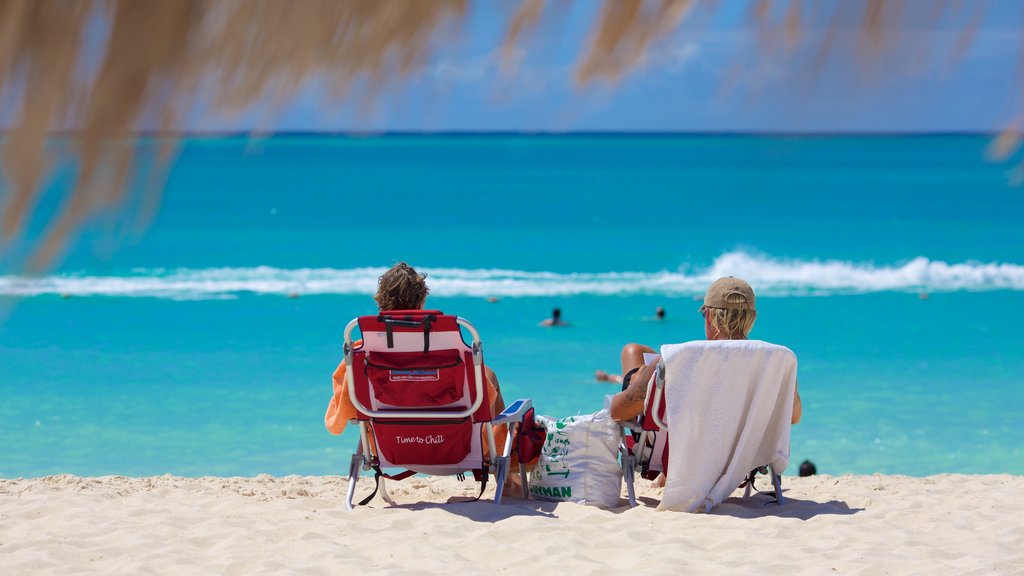 Eagle Beach featuring a sandy beach as well as a small group of people