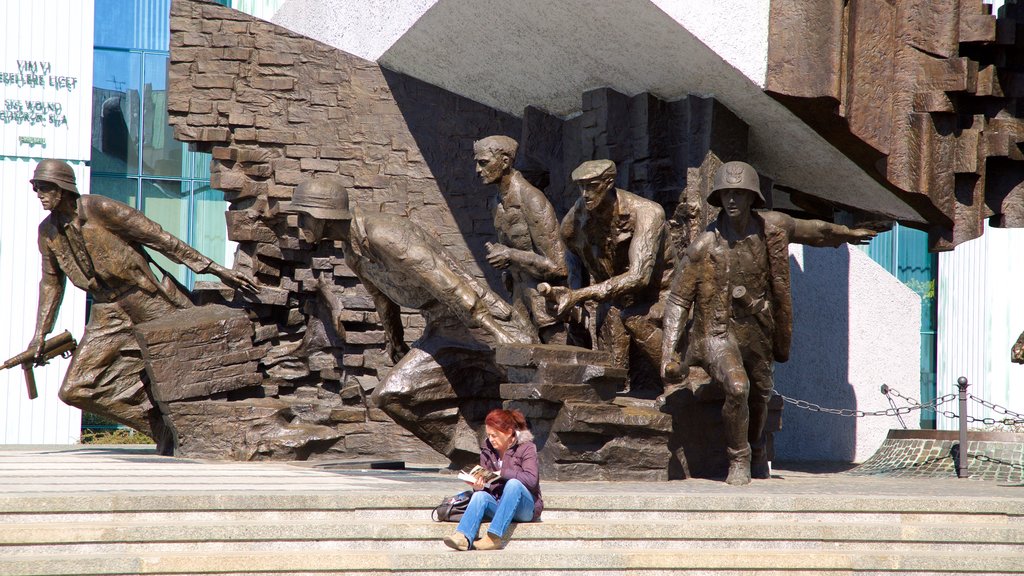 Warsaw Uprising Monument showing a statue or sculpture as well as an individual femail