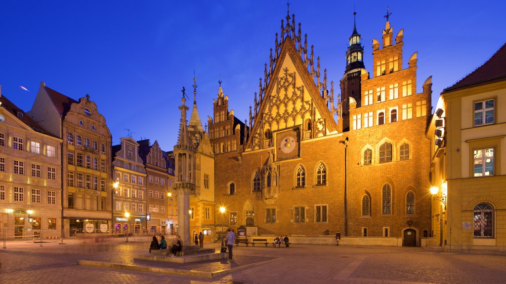 Ayuntamiento de Wroclaw que incluye escenas nocturnas y un parque o plaza