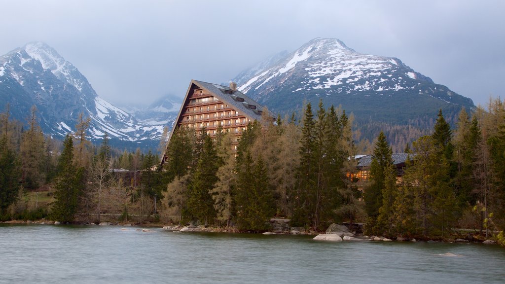 Strbske Pleso which includes a house, a lake or waterhole and forest scenes