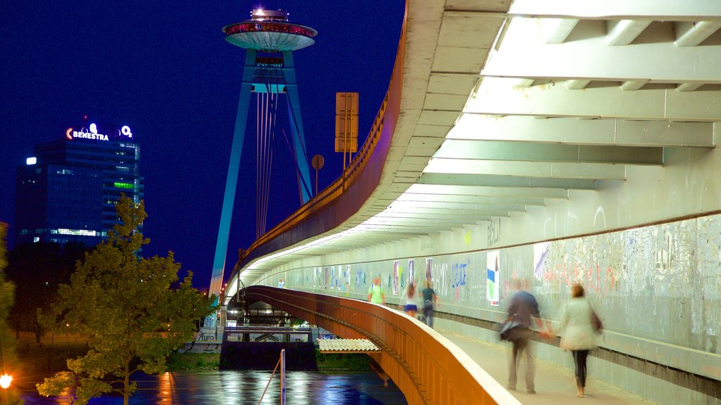 Puente nuevo ofreciendo un río o arroyo, escenas de noche y arquitectura moderna