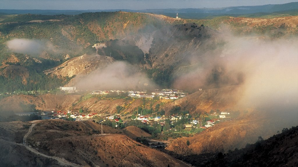 Queenstown which includes mountains, a small town or village and mist or fog