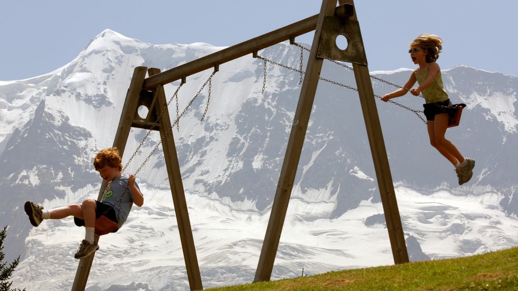 Mürren som viser fjell og lekeplass i tillegg til barn