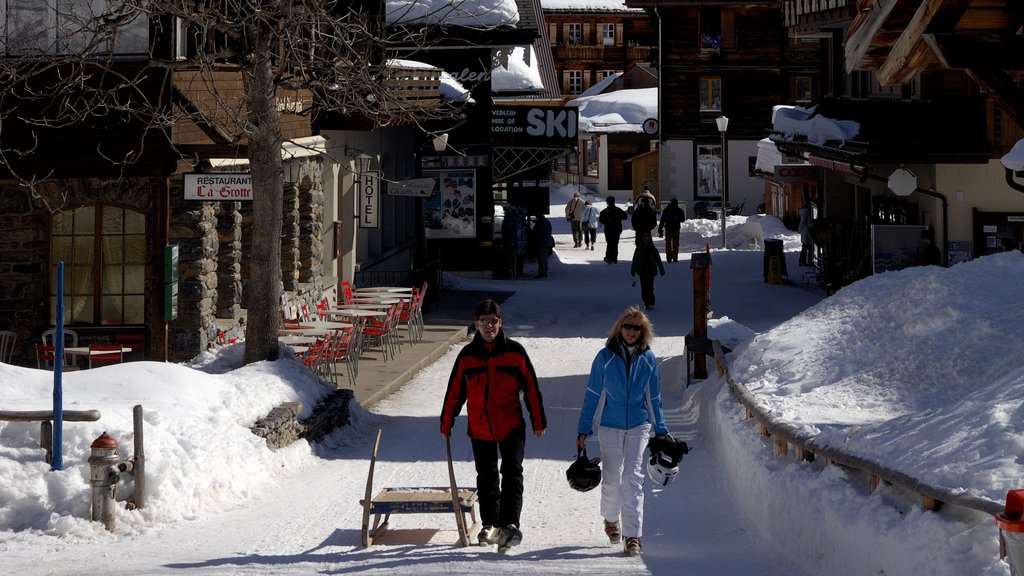 Mürren ofreciendo una pequeña ciudad o aldea y nieve y también una pareja