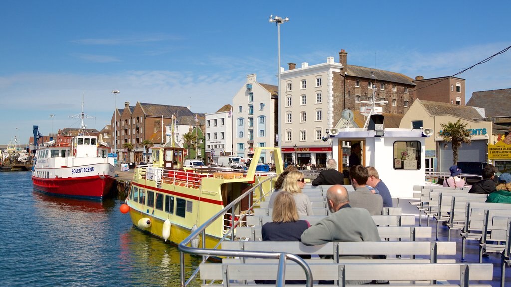 Poole Harbour showing a bay or harbour as well as a small group of people