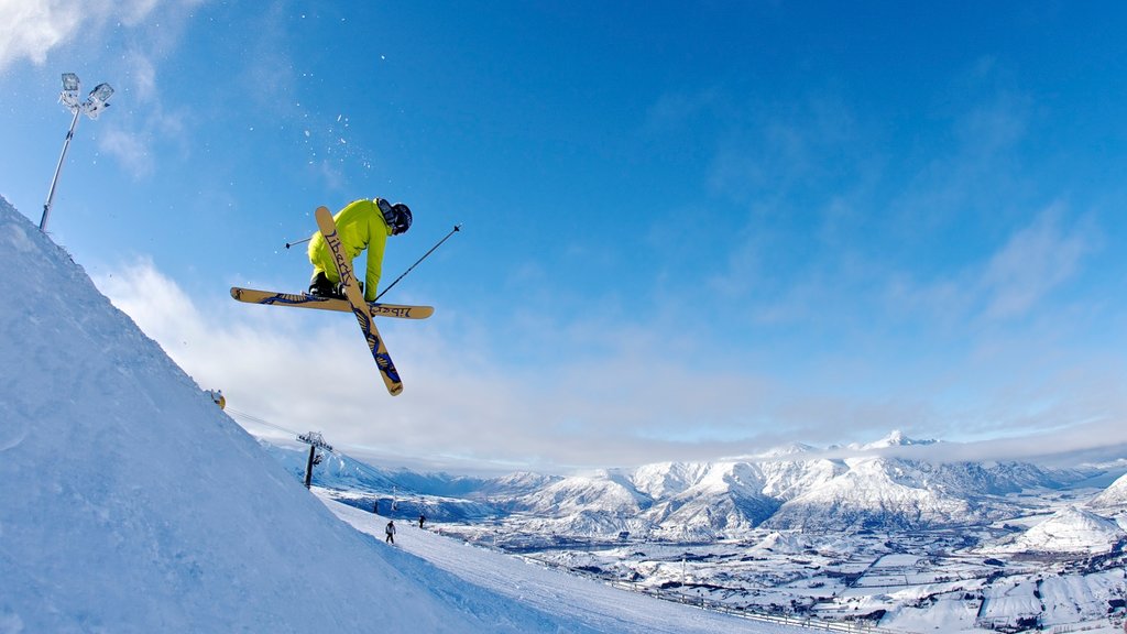 Área de esqui Coronet Peak mostrando esqui na neve assim como um pequeno grupo de pessoas