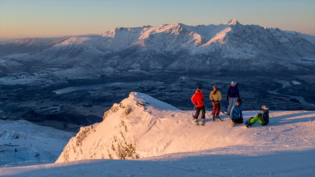 Estación de esquí Coronet Peak mostrando nieve y también un pequeño grupo de personas