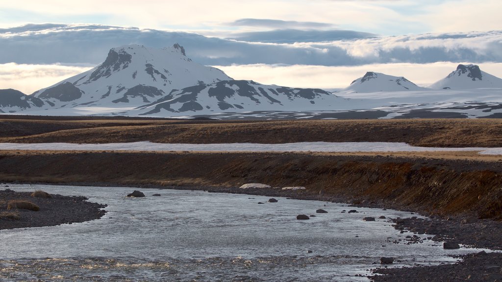 Laugarvatn johon kuuluu vuoret, lunta ja joki tai puro