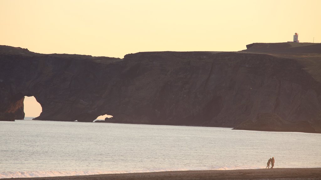 Plage noire mettant en vedette un coucher de soleil et paysages côtiers