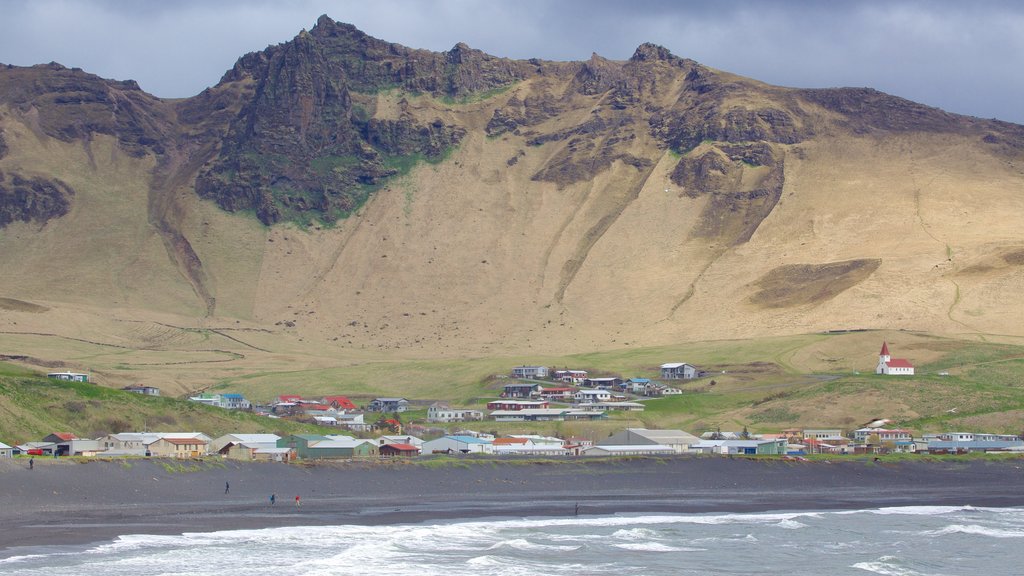 Svart strand som inkluderer kystby, kyst og fjell