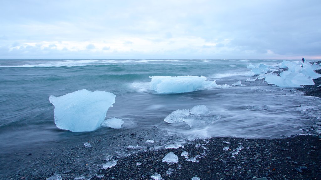 Jökulsárlón johon kuuluu lunta ja kivinen ranta