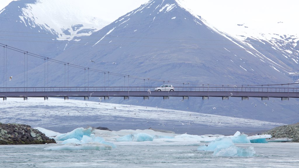 Jökulsárlón johon kuuluu lunta, yleiset rantanäkymät ja silta