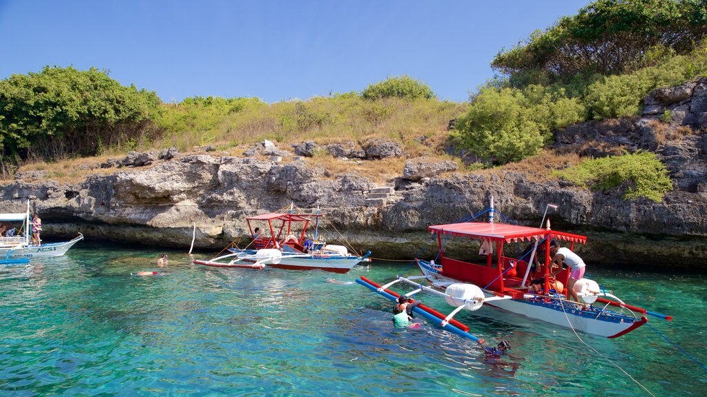 Isla Pescador que incluye costa escarpada y botes