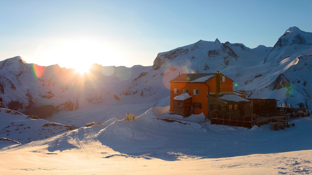 Matterhorn som inkluderer snø, hus og solnedgang