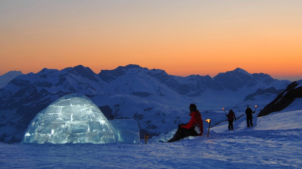 Estação de Esqui Engelberg-Titlis caracterizando um pôr do sol e neve assim como um pequeno grupo de pessoas