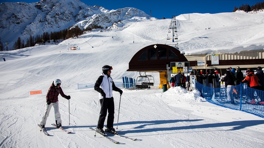 Courmayeur featuring snow and snow skiing as well as a small group of people