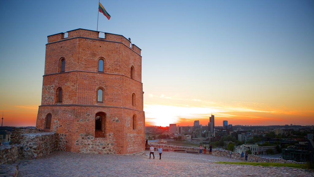 Torre Gediminas que inclui um pôr do sol e um pequeno castelo ou palácio